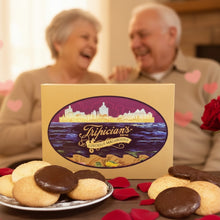 Load image into Gallery viewer, A Tripician branded gift box lid propped up behind a table woth almond and chocolate covered almond macaroons