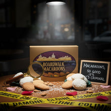 Load image into Gallery viewer, Boardwalk Macaroons display with magnifying glass and decorative elements on a dark background