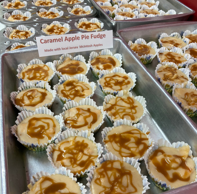 Caramel apple pie fudge in paper cups on a tray with a sign indicating the flavor and ingredients.