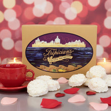 Load image into Gallery viewer, A box f Tripician's brnaded coconut macaroons on a table with macaroons, a red coffee cu and rose petals scattered
