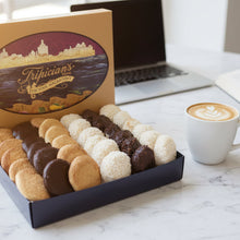 Load image into Gallery viewer, Box of assorted macaroons with a Tripician's logo on a blurred restaurant background
