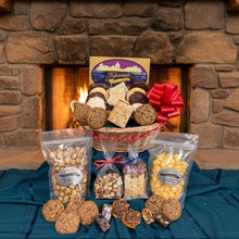 Load image into Gallery viewer, Gourmet gift basket with cookies and snacks in front of a stone fireplace
